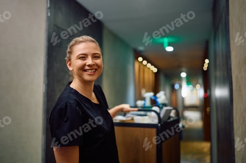 Preview: Young happy hotel housekeeper looking at camera.