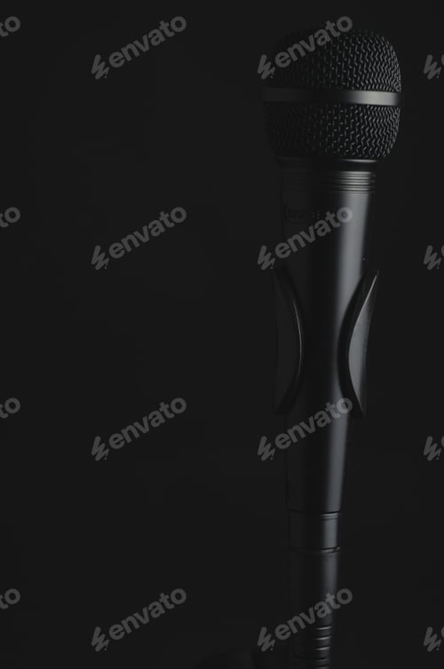 Preview: Vertical closeup shot of a black microphone on a black background