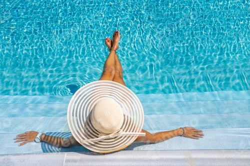 Preview: woman in luxury spa resort near the swimming pool.