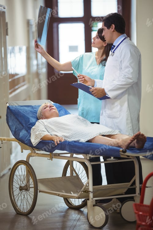 Preview: Doctor and nurse examining report in corridor