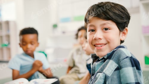 Preview: Portrait Of Male Elementary School Pupil With Teacher Reading To Class In Background