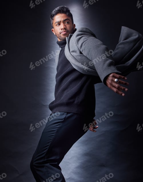Preview: Studio shot of a handsome and fashionable young man posing against a dark background