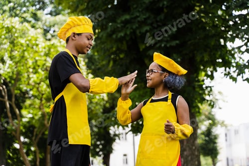 Preview: Kids in yellow chef outfits clapping hands, brother and sister enjoying baking together