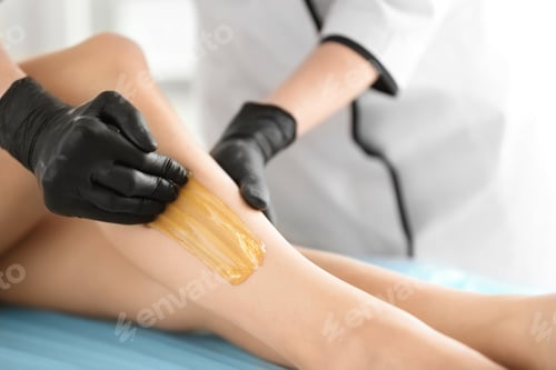 Preview: Woman getting wax epilation in salon