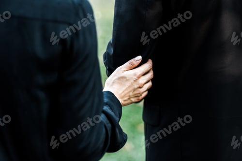 Preview: cropped view of woman touching senior man on funeral