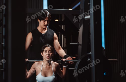 Preview: Woman working out Bodybuilder with coaching assistance to support weights.