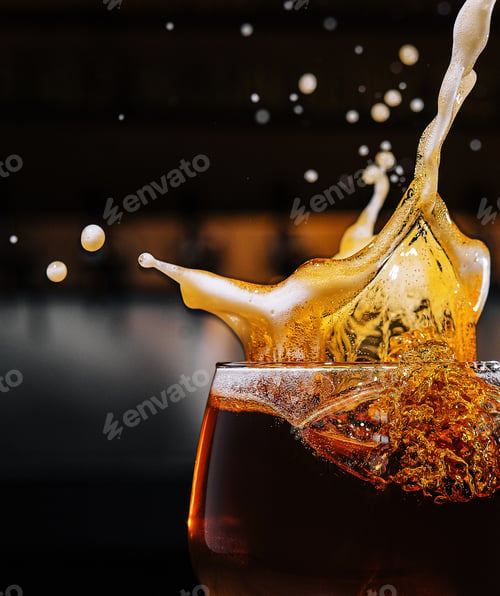 Preview: closeup splashes glass of dark Belgian beer