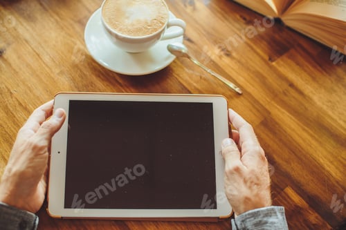 Preview: Men's hands hold the tablet with coffee