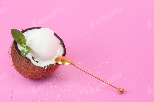 Preview: Vanilla ice cream balls in a fresh coconut half decorated with mint leaves with a spoon on a pink