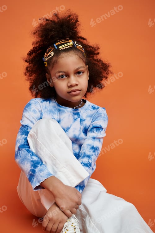 Preview: Stylish girl with hair clips on orange background