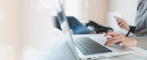 Preview: woman hands working with laptop and holding smartphone for digital communication