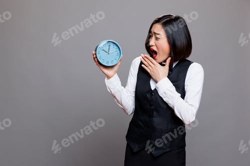 Preview: Waitress yawning, looking at alarm clock