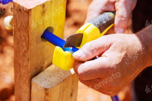 Preview: Water piping is cut with saw tool by a plumber using blue plastic PVC water piping