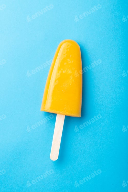Preview: Single homemade orange popsicle on a blue background. Top view