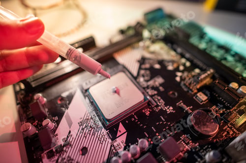 Preview: A person is holding a white pen and pointing at a computer chip