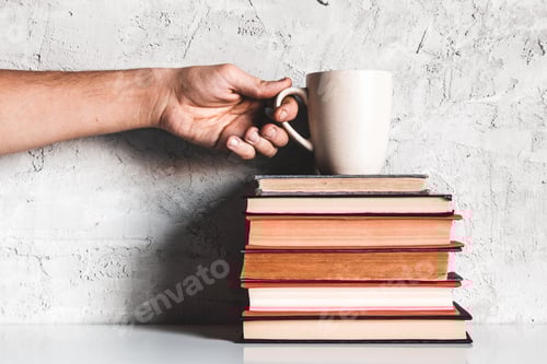 A man takes coffee from a stack of books. Education, learning, reading, hobbies