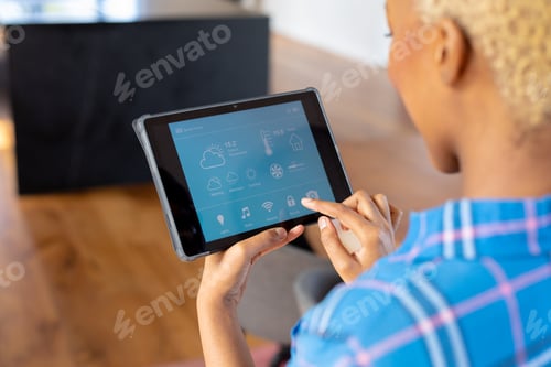 Preview: African american woman using tablet with smart home interface