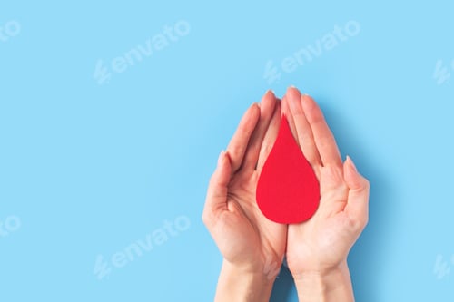 Preview: World hemophilia day concept with red blood drop simbol and hands on blue background
