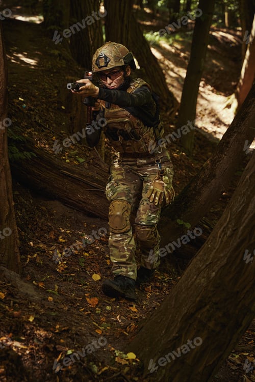 Preview: Female person in helmet standing in wood and holding gun in hands