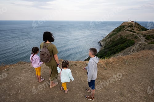 Preview: Mother and children looking at the sea from the top of a mountain.