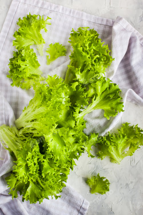 Preview: Fresh raw green frillice iceberg lettuce salad on table, top vie