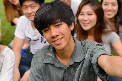 Preview: Happy young group of friends taking selfie together at the park