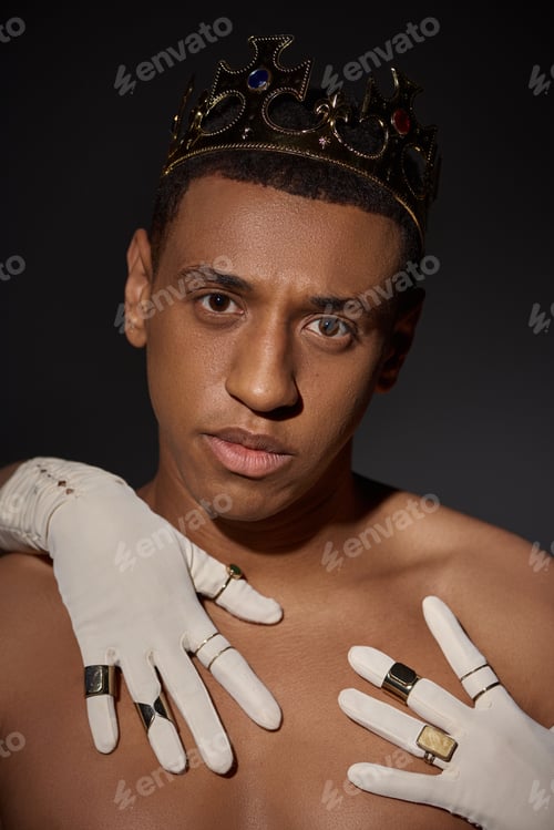Preview: female hands in white gloves with rings near face of shirtless african american man with crown