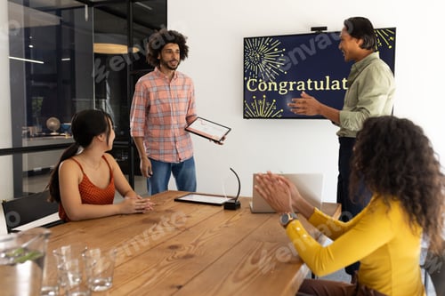 Preview: Celebrating success, team in office meeting applauding colleague's achievement, smiling