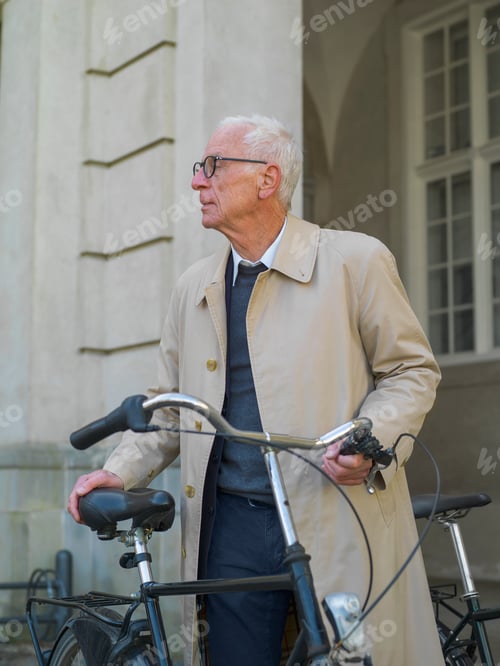 Preview: Elegant senior man with his bicycle in the city