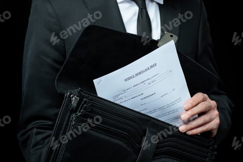 Preview: Mid section of businessman in suit holding briefcase with papers isolated on black