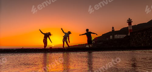 Preview: Sunset Silhouettes: Friends Jumping on Coastline Rocks