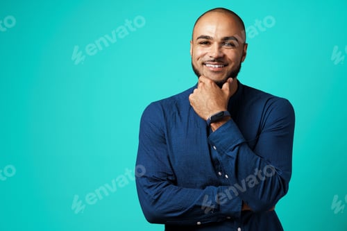 Preview: Portrait of a dark-skinned cheerful smiling man against turquoise background