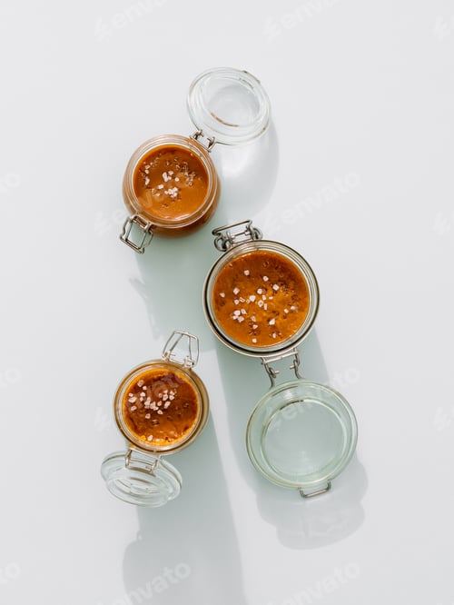 Preview: Salted caramel in glass jars, top view. Vertical