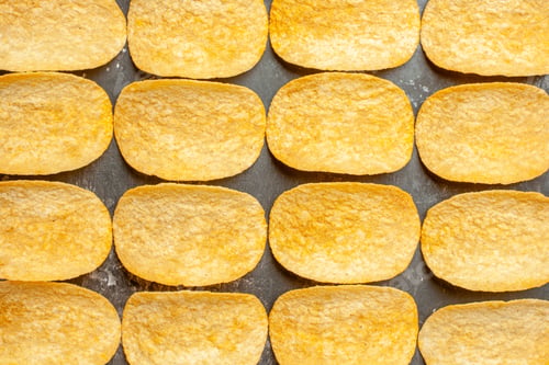 Preview: Close up view of snack party for friends with delicious potato chips on gray background