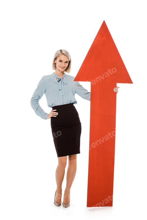 Preview: young businesswoman standing with big red arrow isolated on white