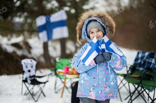 Preview: Finnish little girl with Finland flags on a nice winter day. Nordic Scandinavian people.