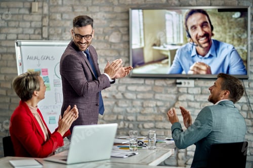 Preview: Happy entrepreneurs applauding to their colleague after successful video conference.