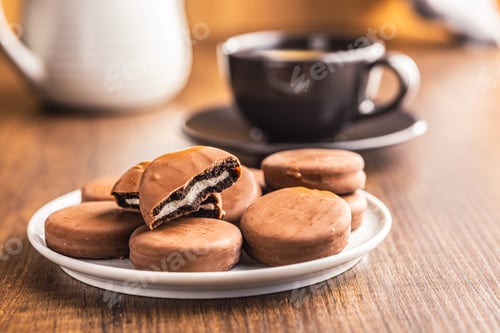 Preview: Close-Up View of Chocolate-Coated Sandwich Cookies on wooden table.