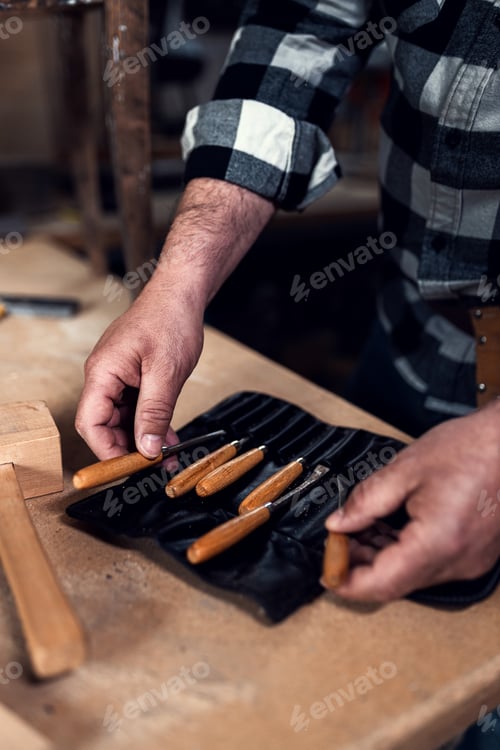 Preview: Close up of male carpenters hands choosing the carving tool.