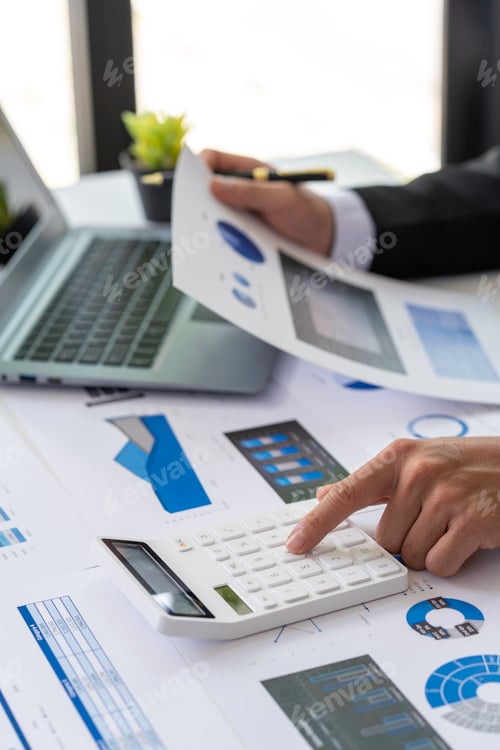 Preview: businessmen or accountants using a calculator calculates and laptop computer while working analytic