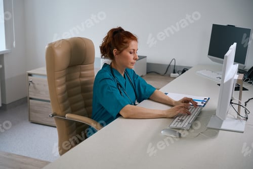 Preview: Professional medic typing on computer keyboard at workplace in clinic office