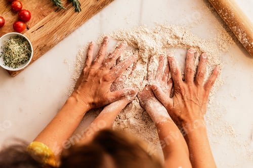 Preview: Little girl kneading flour with her mother.