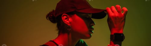 Preview: side view of african american woman in sweatshirt adjusting baseball cap on green with red light,