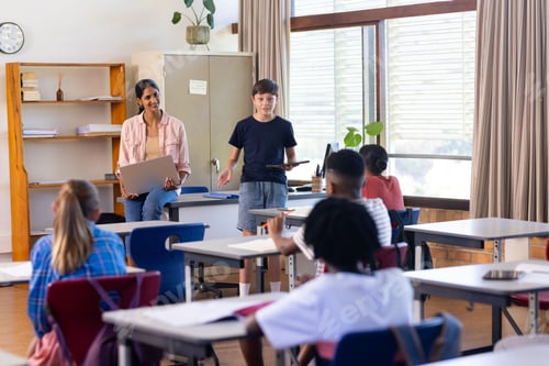 Visualização: Na escola, professora e aluna indianas se apresentando com laptop na sala de aula para colegas