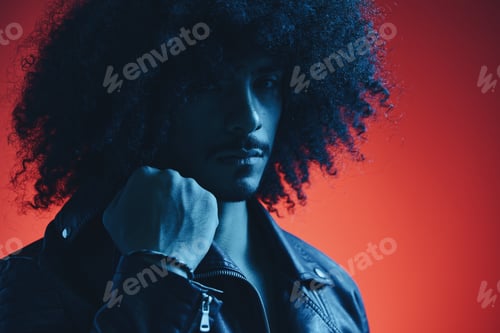Preview: Portrait of fashion man with curly hair on red background multinational, colored light, black
