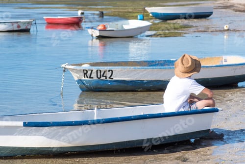 Preview: Boy in boat on the shore.