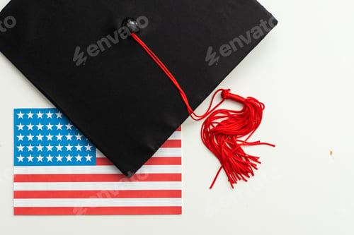 Preview: graduation hat on US flag, education concept