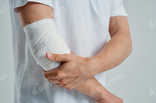 Visualização: male patient in a white T-shirt with a bandaged hand light background