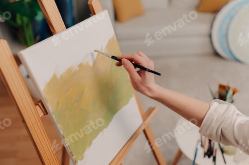 Preview: Female artist painting on canvas with brush in art studio