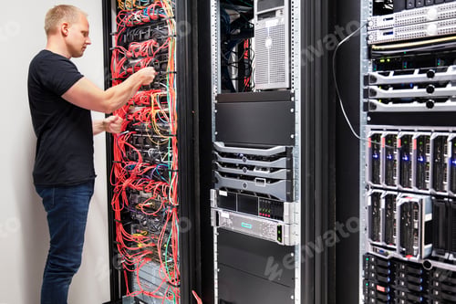 Preview: IT Consultant Working With Network Cables Connected To Servers